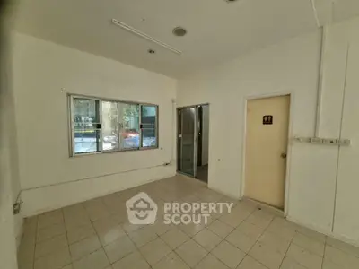 Spacious unfurnished room with tiled flooring and large window