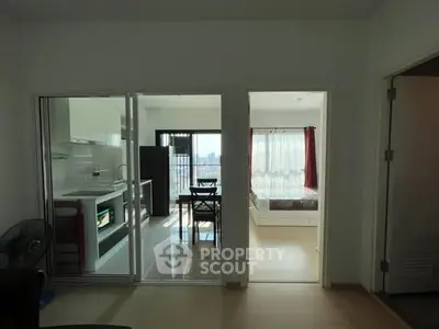 Modern apartment with open kitchen and bright bedroom, ideal for urban living.