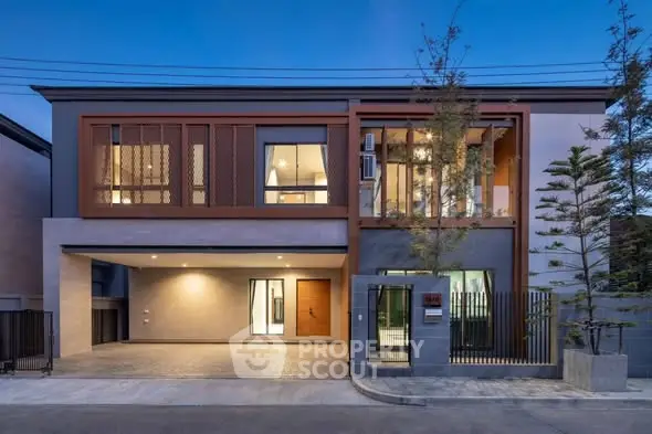 Modern two-story house with spacious garage and stylish facade at dusk.