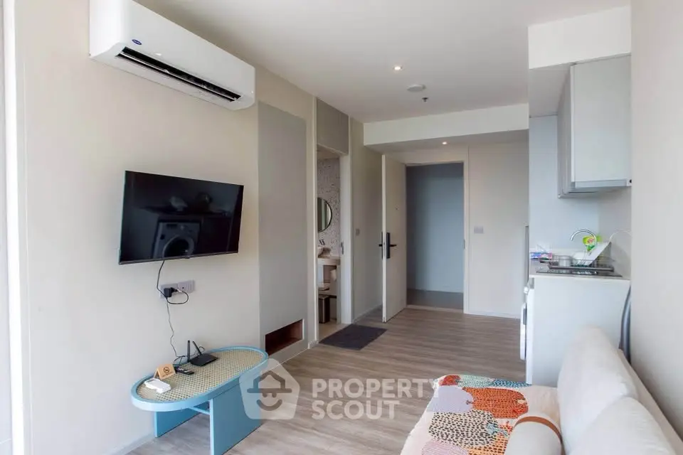 Modern living room with air conditioning and wall-mounted TV in a stylish apartment.
