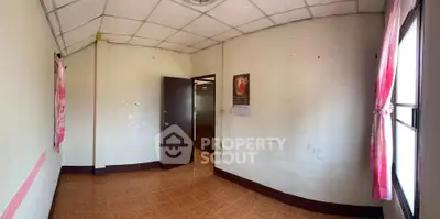 Spacious empty room with tiled floor and natural light, ideal for customization.