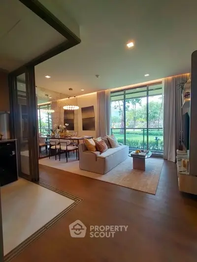 Spacious living room with elegant decor and large windows offering a serene garden view.