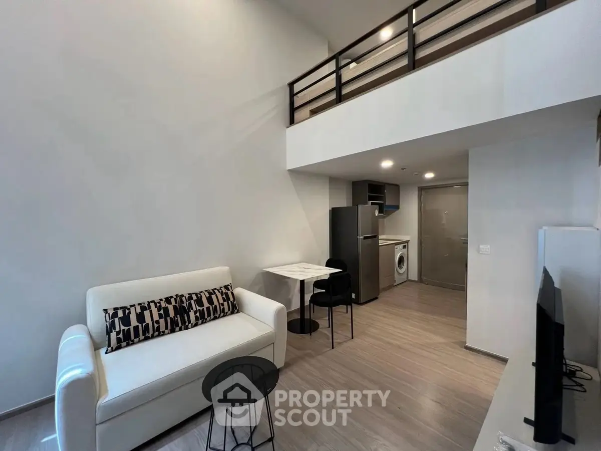 Modern loft apartment with open living area, stylish furniture, and kitchen appliances.