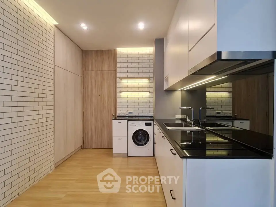 Modern kitchen with sleek cabinetry and built-in washing machine