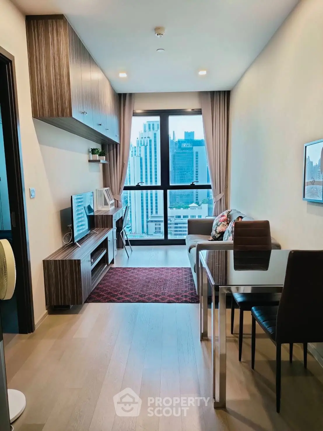 Modern living room with city view, stylish furniture, and natural light.
