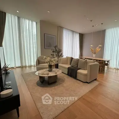 Luxurious modern living room with elegant decor and floor-to-ceiling windows.