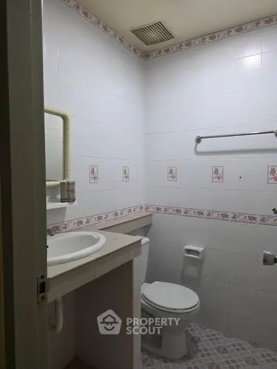 Cozy bathroom with floral tile accents and functional layout