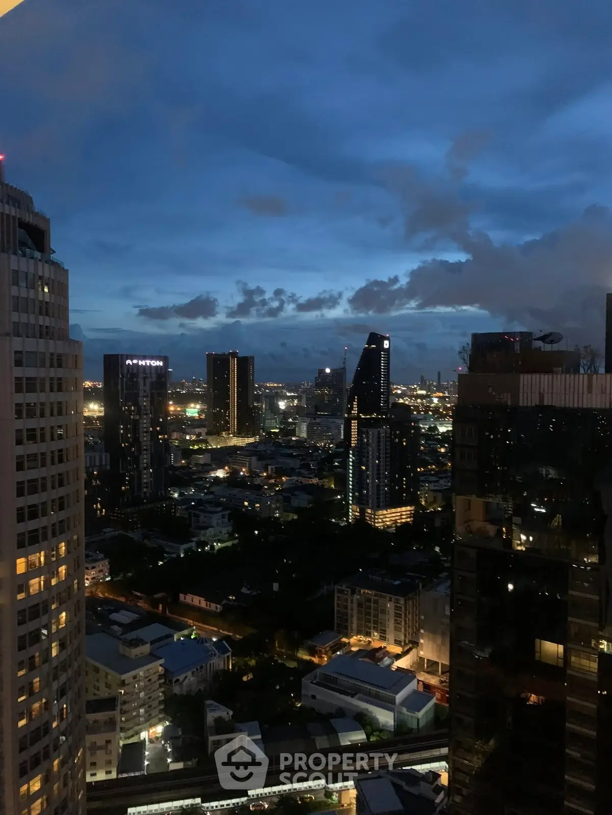 Stunning cityscape view from a high-rise building at dusk, showcasing urban skyline and vibrant city lights.