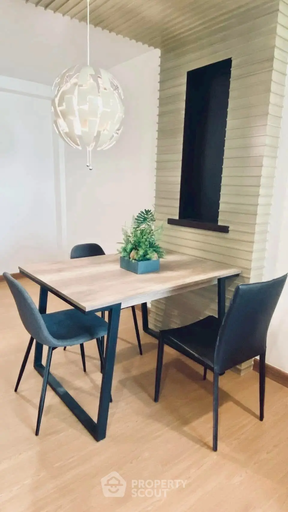 Modern dining area with stylish table and chairs, featuring a unique hanging light fixture.
