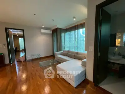 Spacious living room with modern sofa and wooden flooring in a stylish apartment.