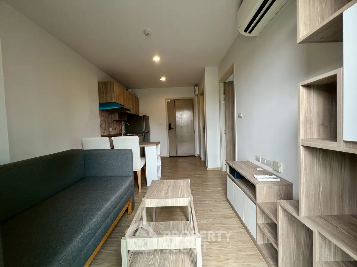 Modern living room with sleek furniture and open kitchen layout in a stylish apartment.