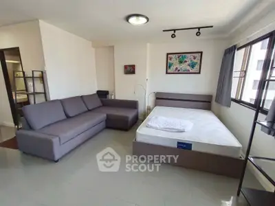 Spacious studio apartment with modern furnishings and large windows for natural light.