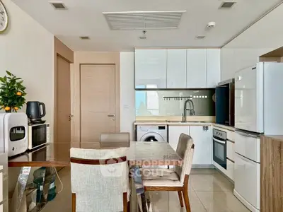 Modern kitchen with dining area, featuring sleek appliances and stylish cabinetry.