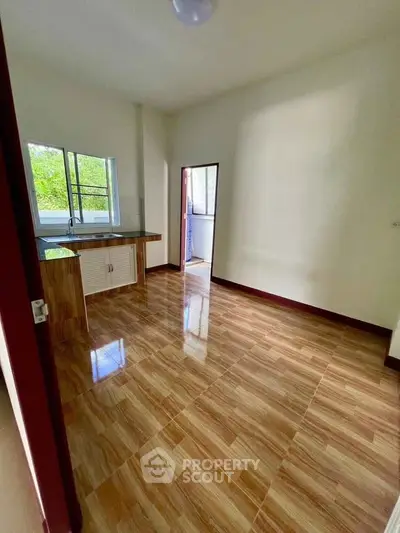 Spacious kitchen with glossy tile flooring and ample natural light, perfect for culinary enthusiasts.