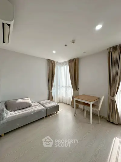 Bright and airy living room with modern furniture and large windows in a stylish apartment.