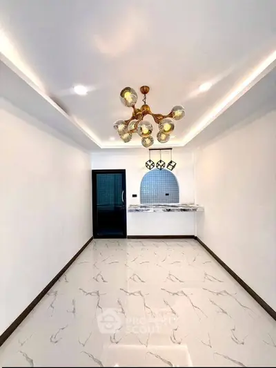Modern living room with elegant chandelier and marble flooring in a stylish apartment.