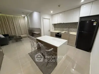 Modern open-layout kitchen with sleek design and dining area in a stylish apartment.