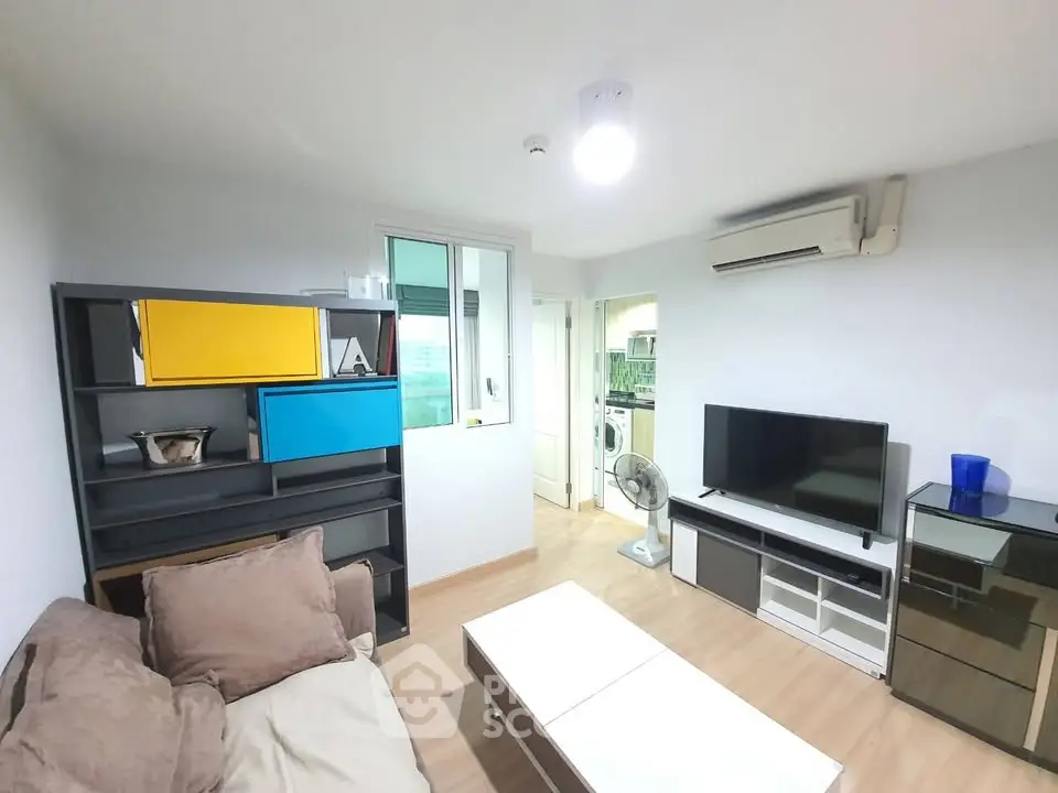 Modern living room with sleek furniture and air conditioning, featuring a cozy sofa and entertainment center.