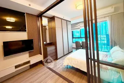 Modern bedroom with mirrored wardrobe and city view, featuring sleek design and natural light.