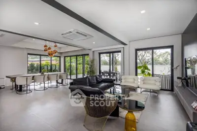 Spacious modern living room with stylish furniture and large windows offering garden views.