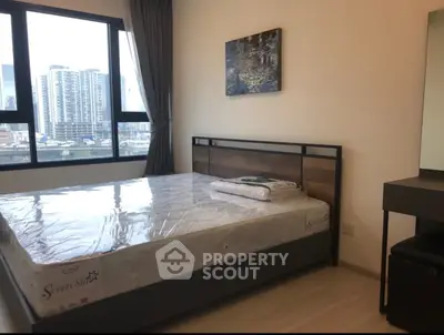 Modern bedroom with city view, featuring a stylish bed and elegant decor.