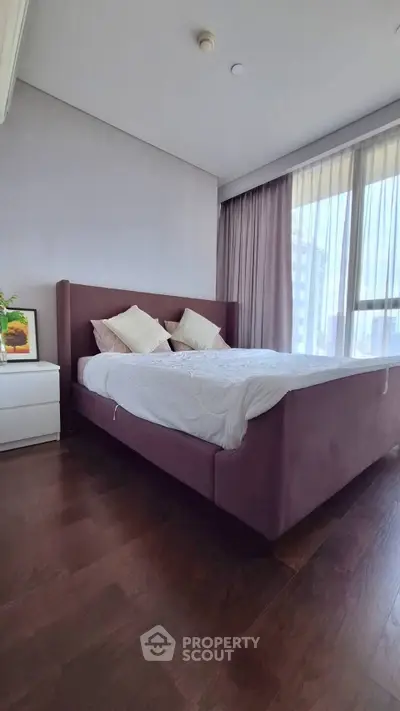 Spacious bedroom with modern design and large windows offering natural light.