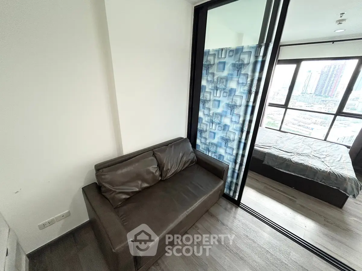 Modern apartment with cozy living area and bedroom, featuring large windows and stylish decor.