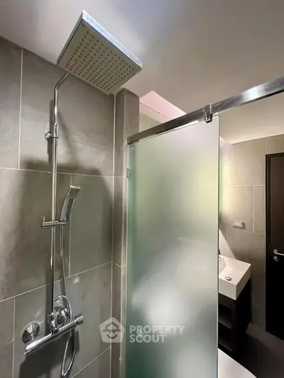 Modern bathroom with sleek shower and frosted glass door in contemporary apartment.