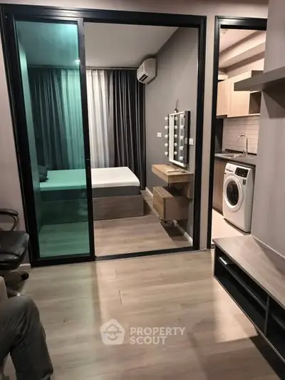 Modern apartment interior with bedroom and kitchen featuring washing machine and sleek design.