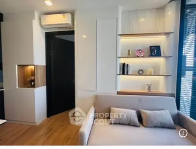 Modern living room with sleek design, built-in shelves, and cozy sofa in a bright apartment.