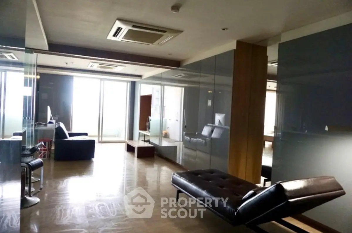 Spacious modern living room with sleek furniture and large windows for natural light.