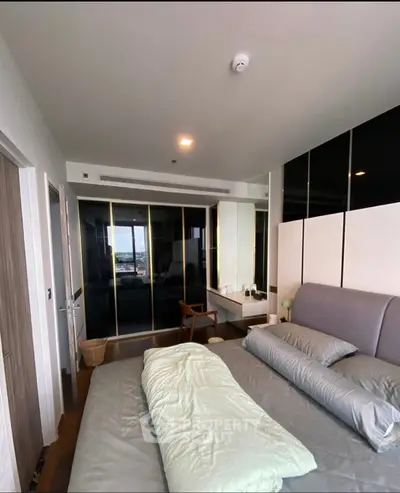 Modern bedroom with sleek design and large window offering a stunning view, featuring a comfortable bed and stylish decor.