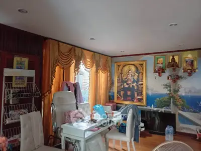 Charming living room with elegant decor and religious artwork, featuring plush seating and warm lighting.