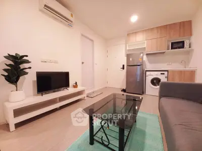 Modern living room with sleek furniture, washing machine, and air conditioning in a cozy apartment.