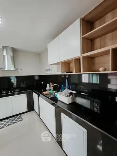 Modern kitchen with sleek black and white cabinetry and built-in appliances