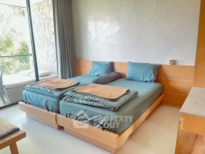 Spacious bedroom with twin beds and balcony access in modern apartment