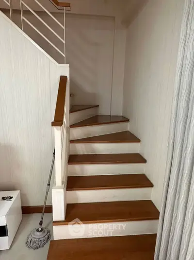 Elegant wooden staircase with modern railing in a cozy home interior.