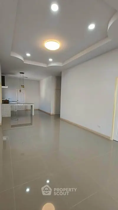 Spacious modern living room with open layout and stylish ceiling lights.