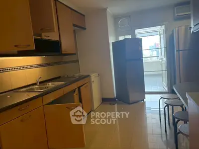 Spacious kitchen with modern appliances and ample storage in a well-lit apartment.