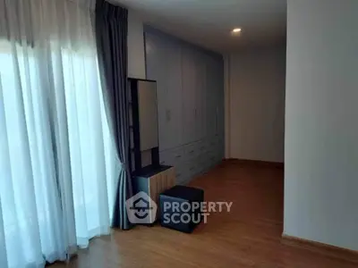 Spacious bedroom with elegant wooden flooring and ample closet space