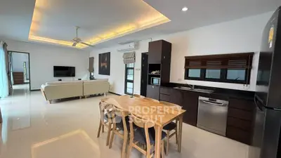 Spacious open-plan living room and kitchen with modern furnishings and natural light.