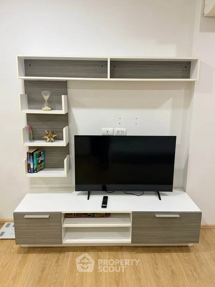 Modern living room with sleek TV stand and wall-mounted shelves, perfect for stylish home entertainment setup.