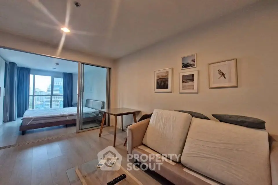 Modern living room with cozy sofa and bedroom view in open layout apartment