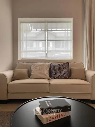 Cozy living room with stylish sofa and decorative pillows, perfect for relaxation.