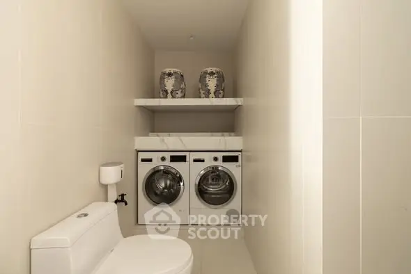 Modern bathroom with integrated laundry appliances and minimalist decor.