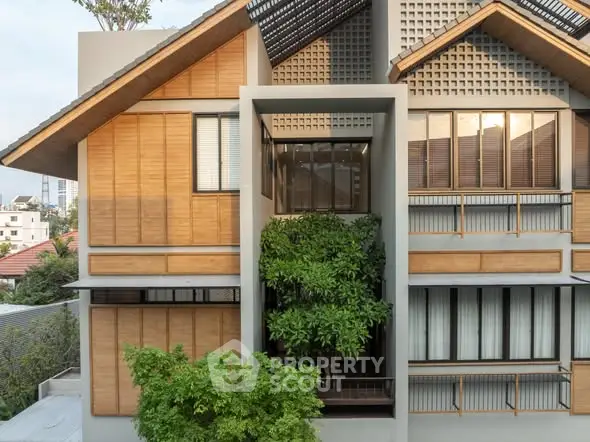 Modern architectural building with wooden accents and lush greenery in urban setting.