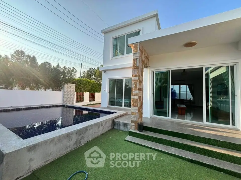 Modern two-story house with private pool and lush green lawn