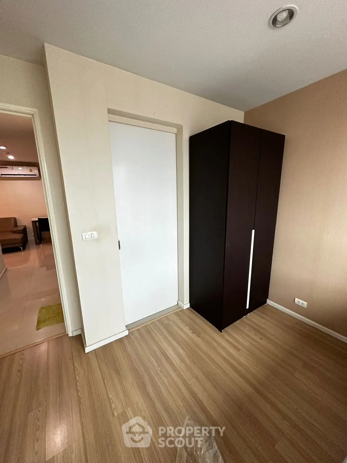 Spacious room with wooden flooring and modern wardrobe in a stylish apartment.