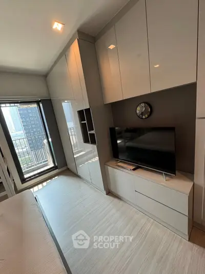 Modern bedroom with sleek storage and city view balcony access