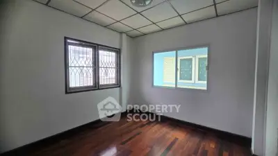 Spacious room with wooden flooring and large windows, perfect for customization.